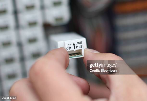 An engineer for BT Openreach part of the BT Group Plc removes a DSL line box from a connection point in Enfield, U.K., on Thursday, Aug. 5, 2010. BT...