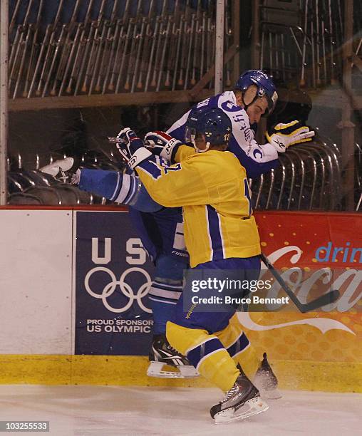 Jonnas Nattinen of Team Finland is hit into the boards by Gabriel Landeskog of Team Sweden at the USA Hockey National Evaluation Camp on August 5,...