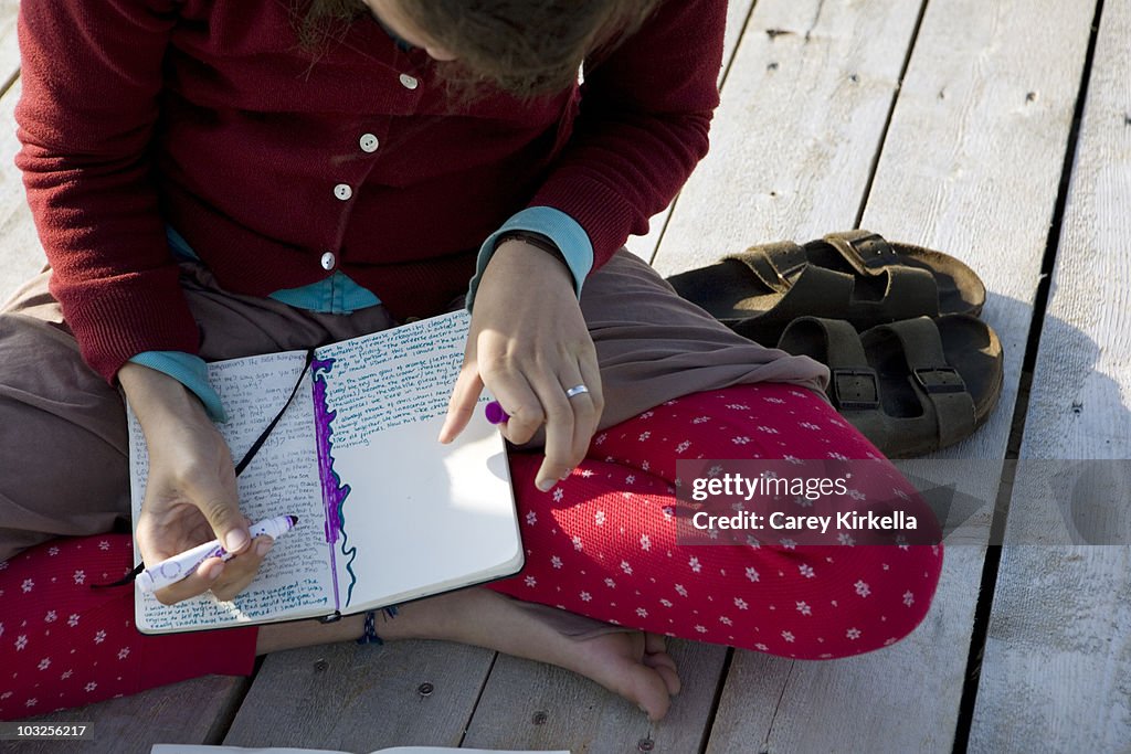 Teenaged girl writing in a journal