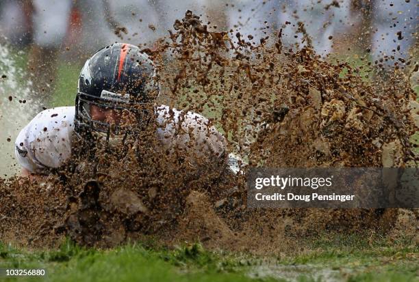 Zane Beadles of the Denver Broncos dives into the mud as rookies partake in the slip and slide fumble drill during training camp at Dove Valley on...