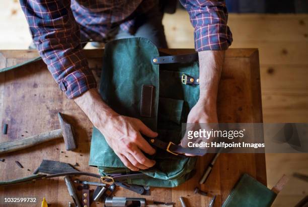 a small business of a craftsman making leather and canvas bags. - sac en cuir photos et images de collection