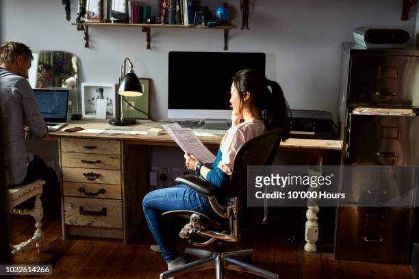small business owner working in home office and checking financial documents - office chair stock pictures, royalty-free photos & images