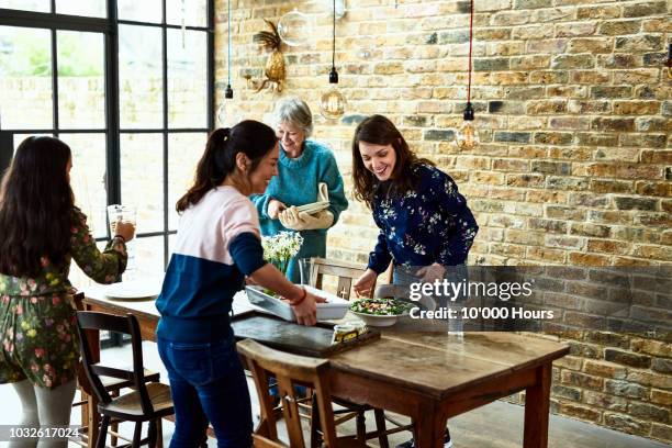 multi racial extended family setting dinner table - setting the table stock pictures, royalty-free photos & images