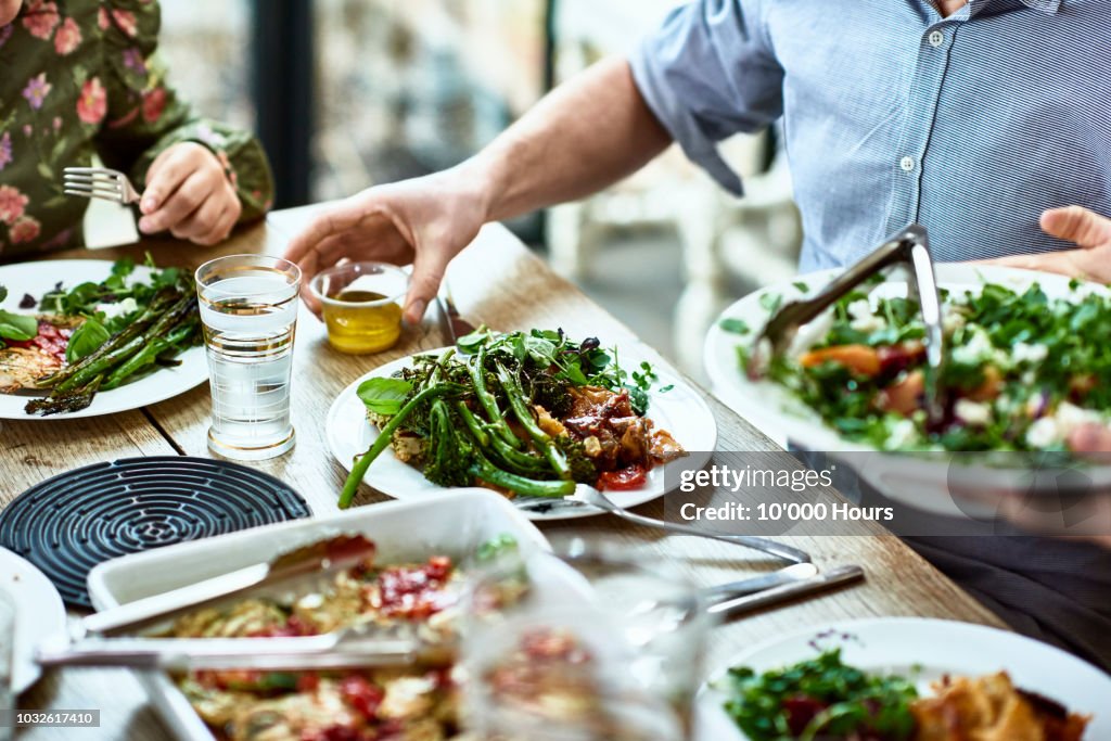 Cropped view of table laid with crockery and fresh homemade vegetarian food