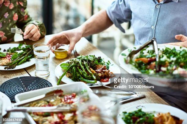 cropped view of table laid with crockery and fresh homemade vegetarian food - meal stock pictures, royalty-free photos & images