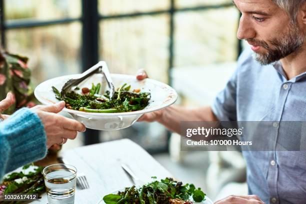 close up shot of mature man being served fresh salad - geniessen teller essen stock-fotos und bilder