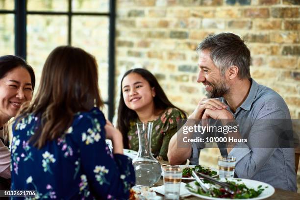 teenage girl relaxing at dinner with her parents and their friends - típico de clase mediana fotografías e imágenes de stock