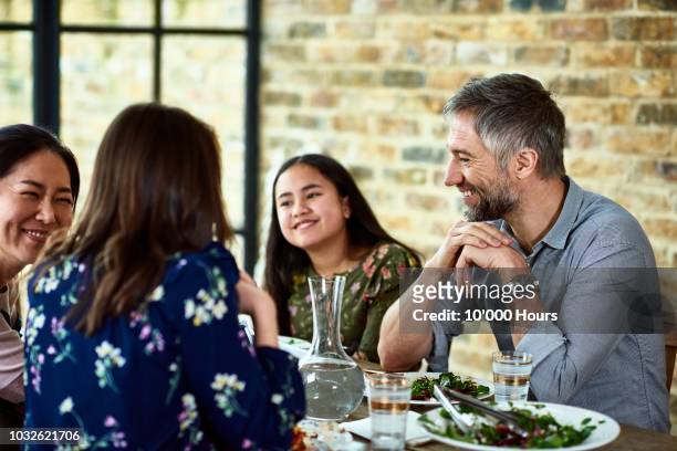 teenage girl relaxing at dinner with her parents and their friends - middle class female stock pictures, royalty-free photos & images