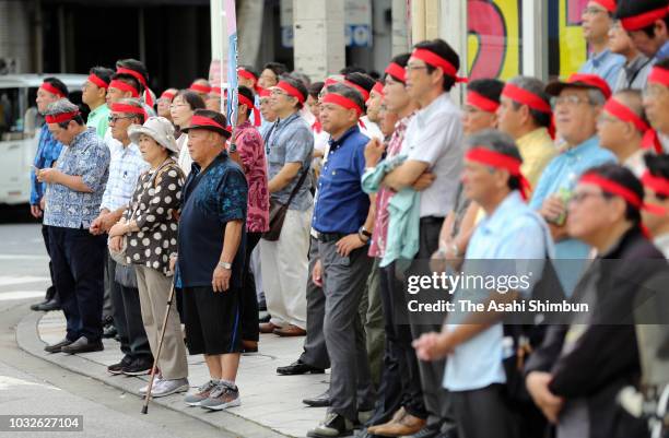 Supporters of ruling Liberal Democratic Party backed candidate Atsushi Sakima listen his street speech as the Okinawa gubernatorial election...