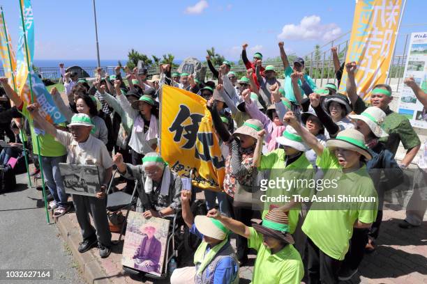 Supporters of opposition 'All Okinawa' movement backed candidate Denny Tamaki raise their fists as the Okinawa gubernatorial election officially...