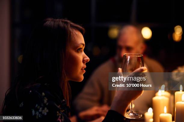 candid postrait of attractive woman holding glass of wine during dinner - family serious stock pictures, royalty-free photos & images