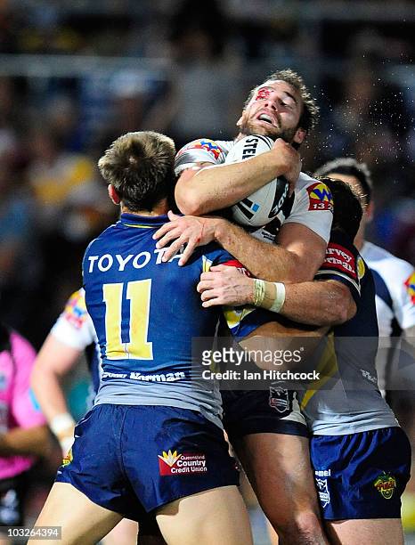Scott Anderson of the Broncos is tackled by Scott Bolton of the Cowboys during the round 22 NRL match between the North Queensland Cowboys and the...