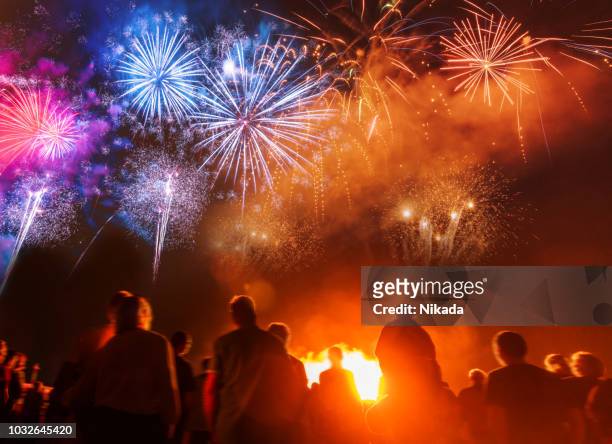 menschen sie stehen vor bunten feuerwerk - new years eve 2019 stock-fotos und bilder