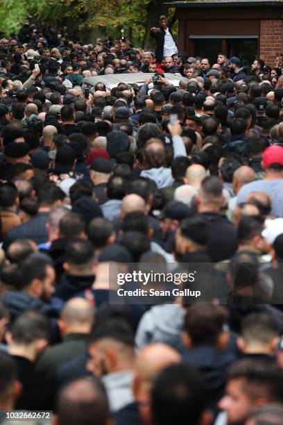 Hearse draped with a Palstinian flag arrives carrying the body of Nidal R., an associate of a Berlin Arab clan, through a crowd of mourners gathered...