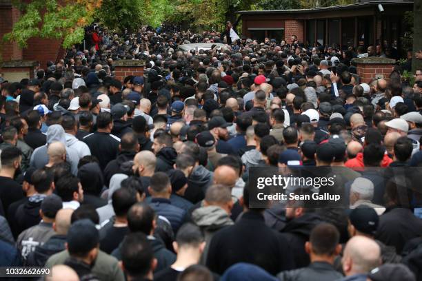 Hearse draped with a Palstinian flag arrives carrying the body of Nidal R., an associate of a Berlin Arab clan, through a crowd of mourners gathered...