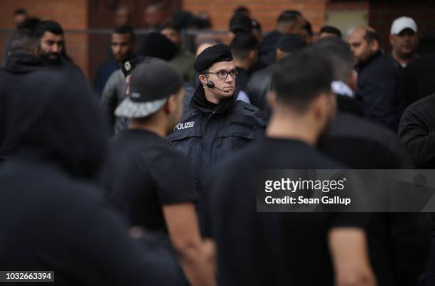 Police watch as mourners arrive for the funeral of Nidal R., an associate of a Berlin Arab clan, outside the New 12 Apostles cemetery on September...