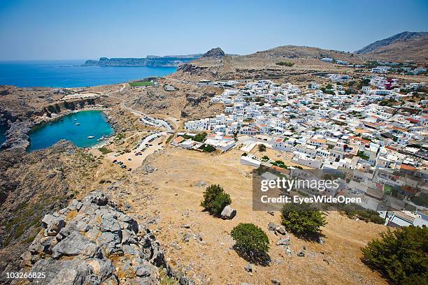 JUlLY 04: View from the Acropolis of Lindos down to the traditional white cubic houses in town and the most beautiful bay, the old harbour Ajios...