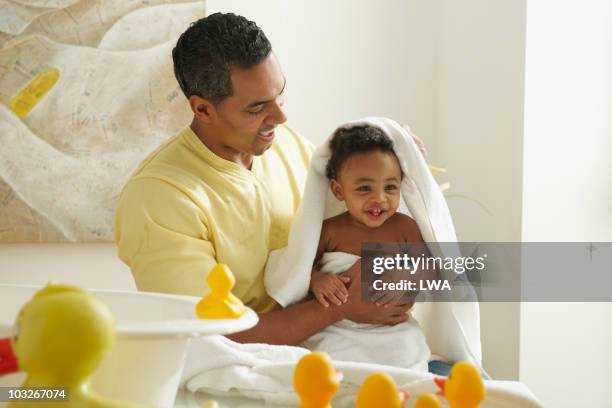 father drying 10 month old son after bath - taking a bath stock-fotos und bilder