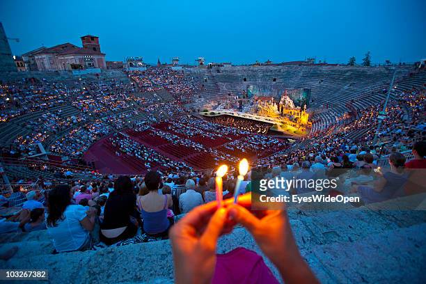 Opera-goers are holding candle lights up at the beginning of the opera Madame Butterfly in the Arena of Verona on July 14, 2010 in Verona, Italy. The...
