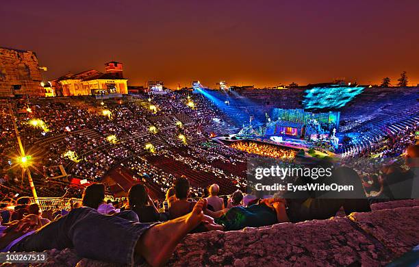 The opera "Madame Butterfly" of Giacomo Puccini is played in the Arena of Verona and visitors relax on the stone steps on July 14, 2010 in Verona,...