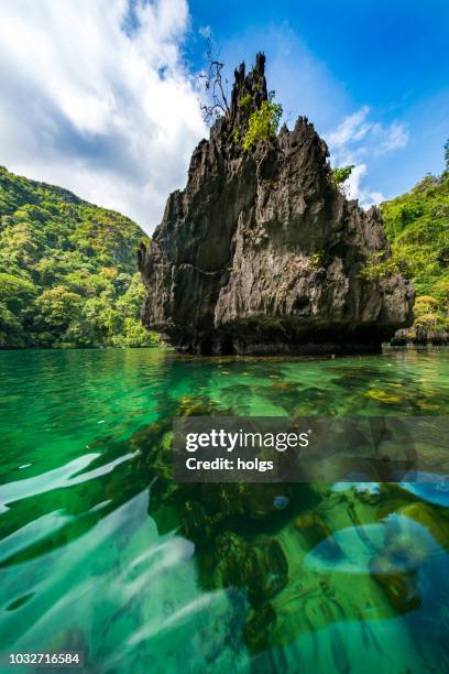 lagoon/lake sorrounded by the rock mountains in the island of el nido, palawan - palawan stock pictures, royalty-free photos & images