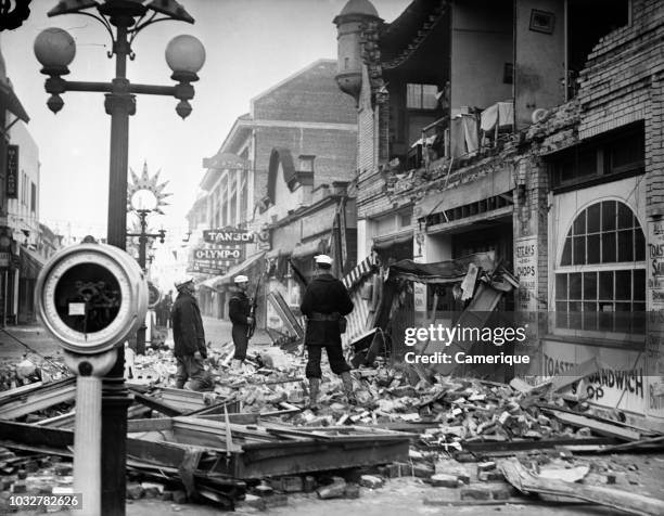 1930s MARCH 10 1933 EARTHQUAKE AFTERMATH MEN SAILORS STANDING IN RUBBLE OF DESTROYED SHOPS RESTAURANTS LONG BEACH CA USA
