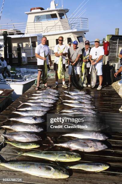 GROUP OF FISHERMEN WITH CATCH OF TUNA AND DOLPHIN FISH OUTER BANKS NORTH CAROLINA USA