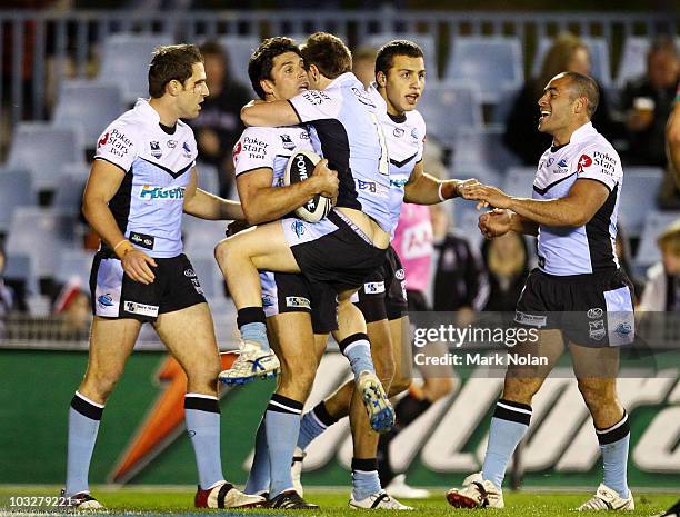 Nathan Gardner of the Sharks congratulates Trent Barrett after Barrett scored during the round 22 NRL match between the Cronulla Sharks and the...