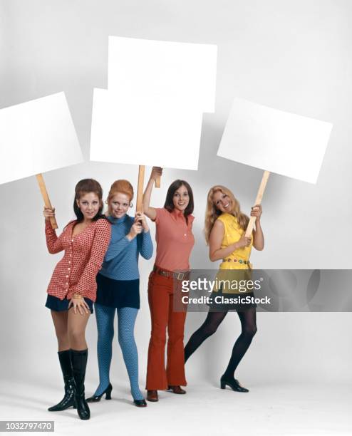 1960s FOUR WOMEN PROTESTERS HOLDING BLANK SIGNS LOOKING AT CAMERA