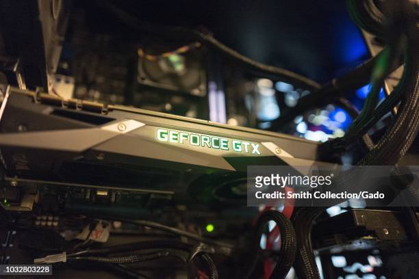 Close-up, low angle view of the interior of a cryptocurrency mining computer designed to mine Bitcoin alternative coins, with glowing logo of an...