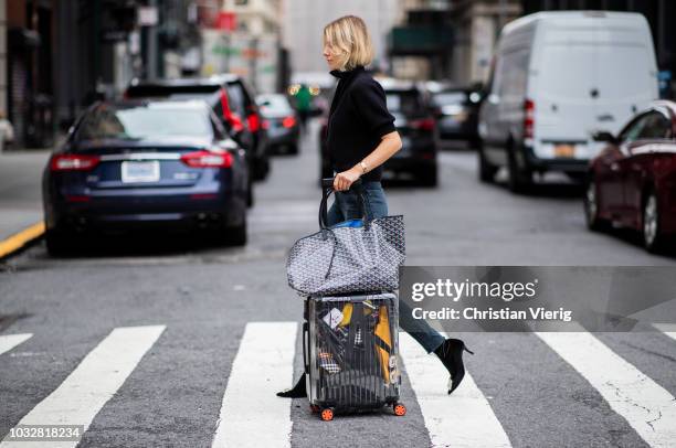 Lisa Hahnbueck wearing velvet Roger Vivier boots, Re/done Levis jeans, Self Portrait turtleneck, Goya bag, Rimowa x Off White travel bag, trolley,...