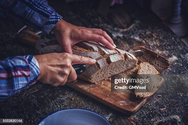 hausgemachtes schwarzbrot schneiden - vollkornbrot stock-fotos und bilder