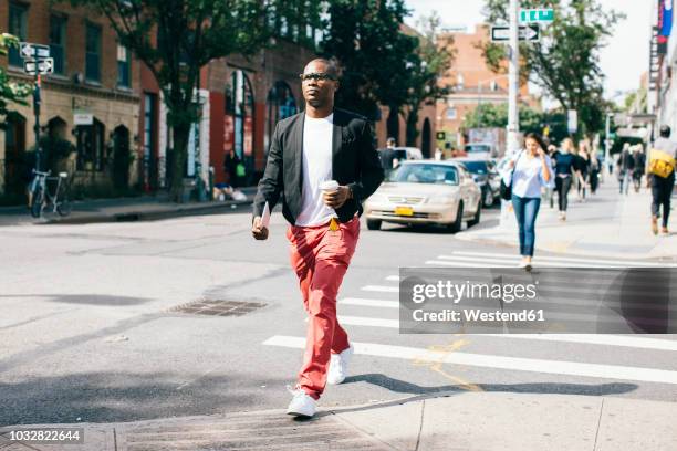usa, nyc, brooklyn, man walking in the street, holding cup of coffee - new york personas fotografías e imágenes de stock