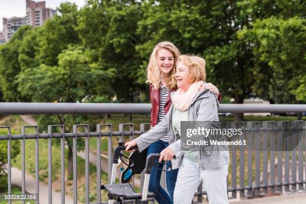 grandmother and granddaughter strolling together - oma rollator stockfoto's en -beelden