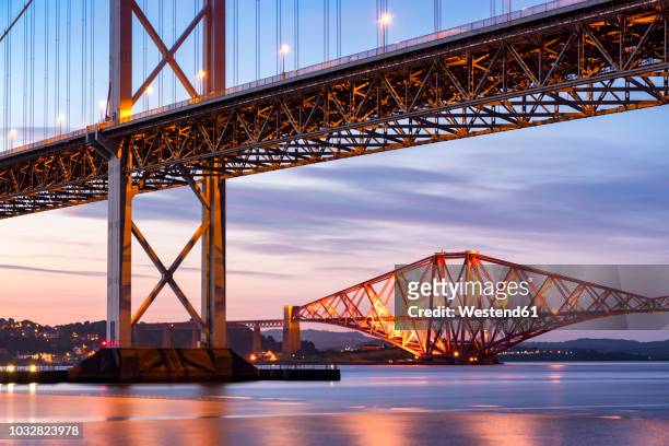 uk, scotland, fife, edinburgh, firth of forth estuary, forth bridge and forth road bridge at sunset - railway bridge stock-fotos und bilder