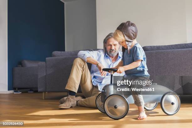 grandfather playing with grandson, sitting on toy car - family inside car bildbanksfoton och bilder