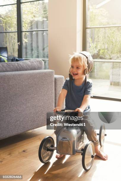 happy blond boy playing on toy car - auto sofa stock pictures, royalty-free photos & images