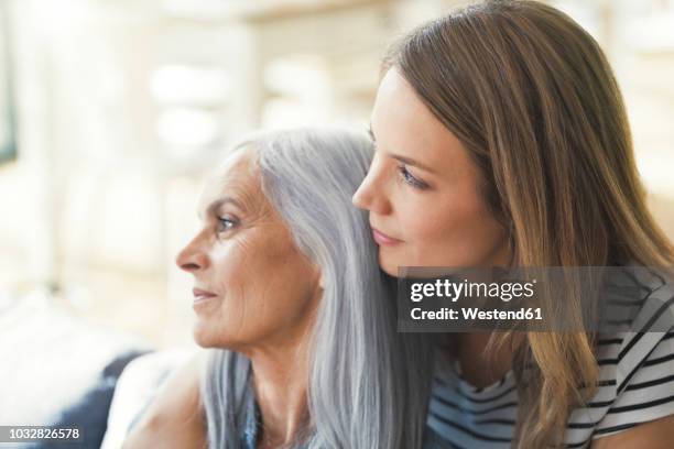 daughter holding mother in her arms - embracing change stock pictures, royalty-free photos & images