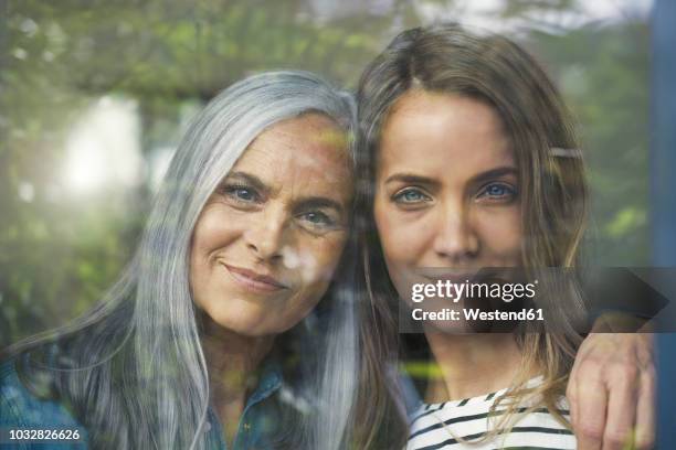 mother and daughter looking out of window - natural change woman stockfoto's en -beelden