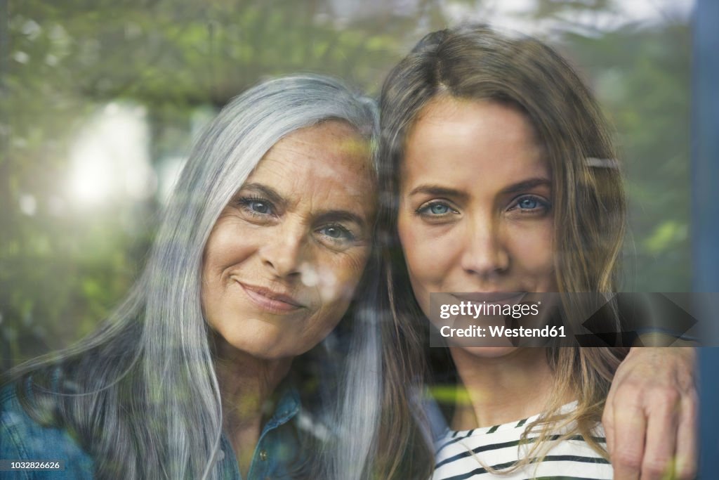 Mother and daughter looking out of window