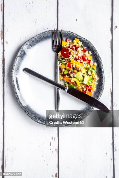bulgar salad on round plate, symbol for intermittent fasting - fasting activity stock-fotos und bilder