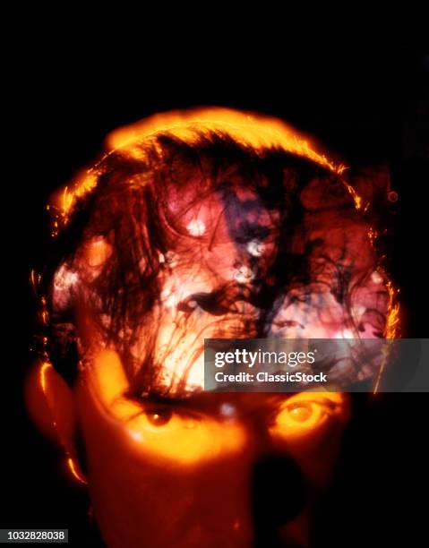 1970s MAN’S FOREHEAD AND FACE LOOKING AT CAMERA WITH BIZARRE SMOKY FIERY SWIRL PATTERNS INSIDE SKULL EVIL TROUBLE MADNESS DRUGS