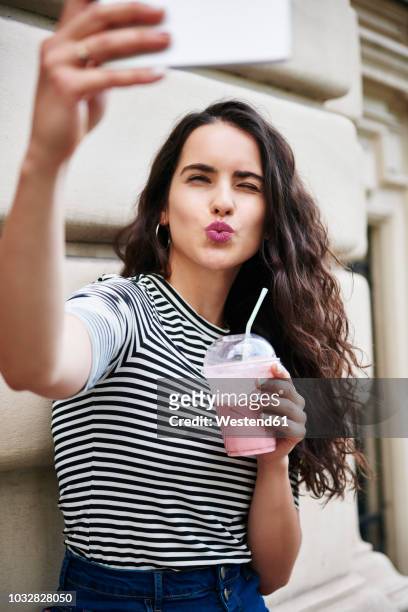 young woman taking a selfie in the city - puckering stock pictures, royalty-free photos & images