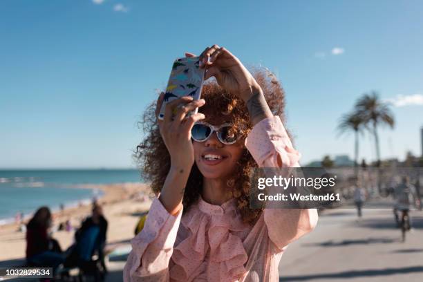 smiling stylish young woman taking a selfie at seaside promenade - beach selfie bildbanksfoton och bilder