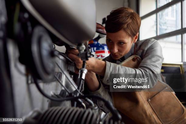 woman working in repair workshop - bike mechanic stockfoto's en -beelden