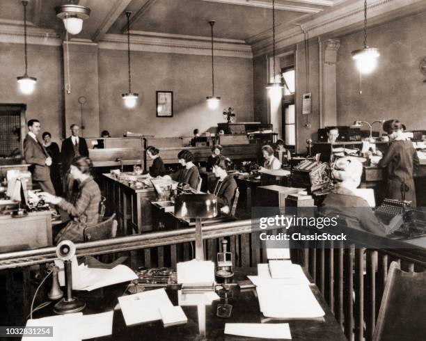 1910s 1920s BUSINESS OFFICE WITH WOMEN SITTING AT DESKS IN BULLPEN AREA