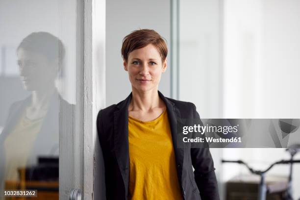 businesswoman with bicycle in her start-up company - portrait yellow stock pictures, royalty-free photos & images