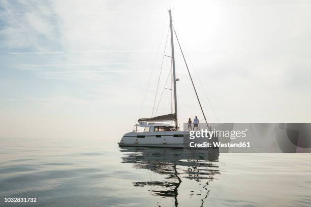 couple setting off for a sailing trip on a catamaran - catamaran race photos et images de collection