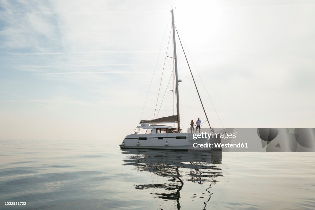 Couple setting off for a sailing trip on a catamaran