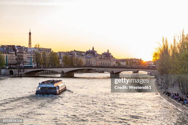 france, paris, pont du carrousel with tourist boat at sunset - seine maritime stock pictures, royalty-free photos & images